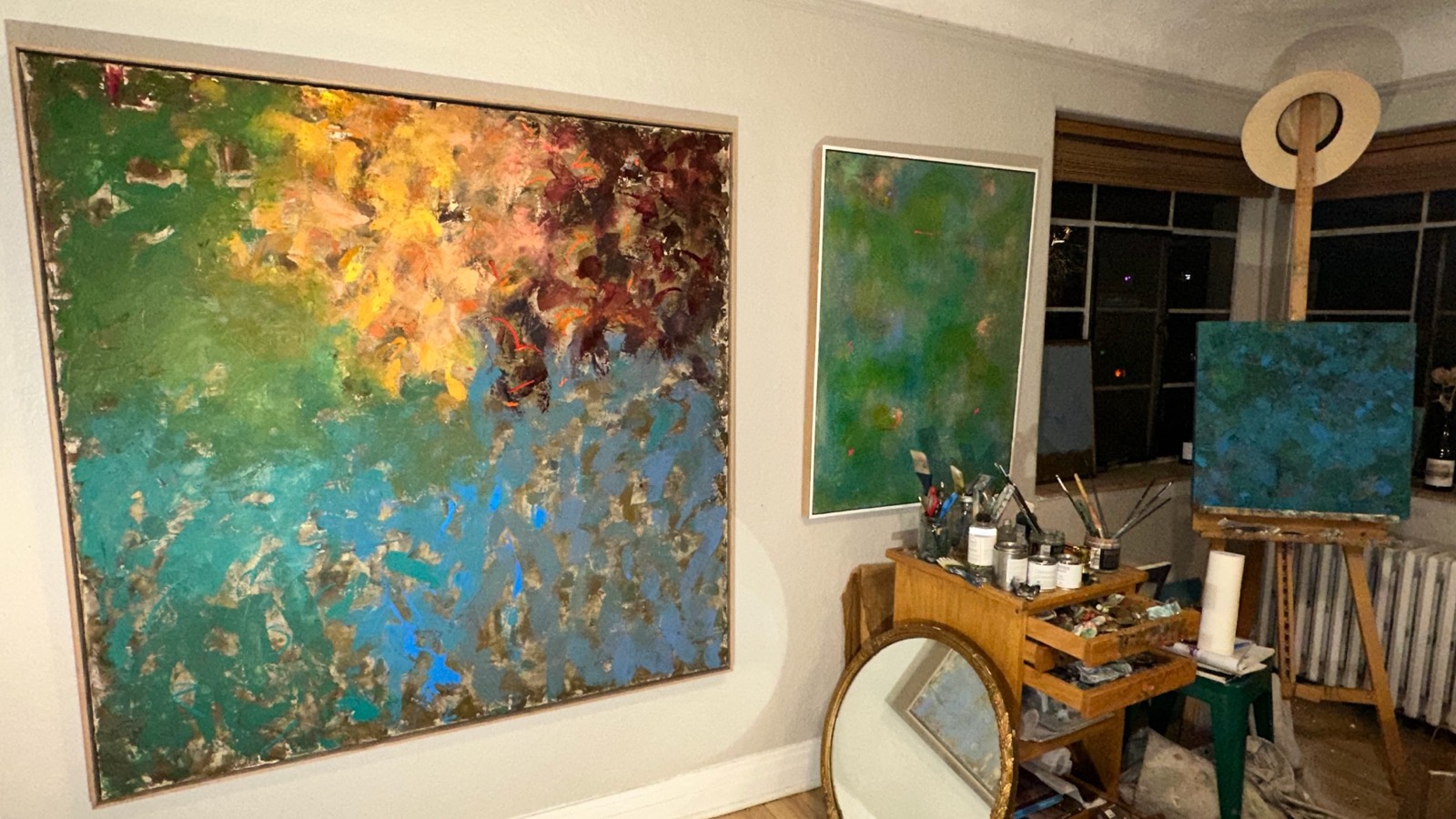 Julie Brayton's studio, with finished canvases on the wall and work in progress on the easel
