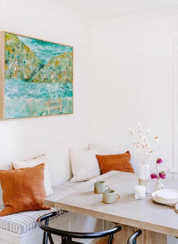 A Julie Brayton painting installed — breakfast banquette